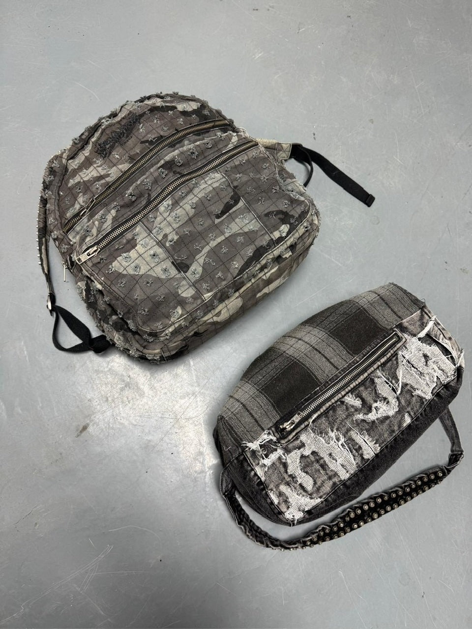 【Reckless Scholars】CAMMO TRASHED STUDDED BACKPACK / 【レックレス スカラーズ】トラッシュスタッズバックパック