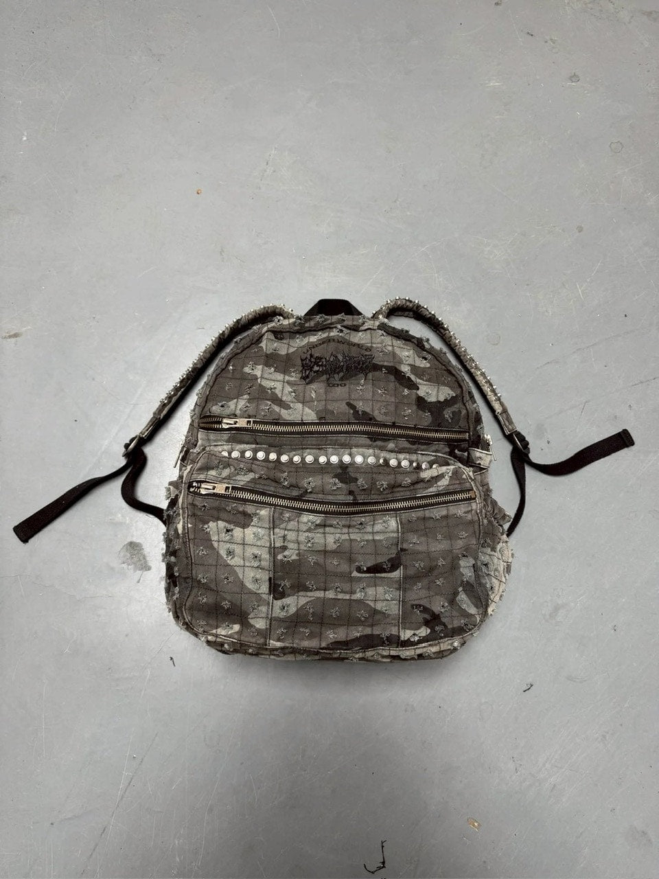 【Reckless Scholars】CAMMO TRASHED STUDDED BACKPACK / 【レックレス スカラーズ】トラッシュスタッズバックパック